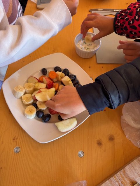 Kinderhände beim Essen von Obst und Gemüse